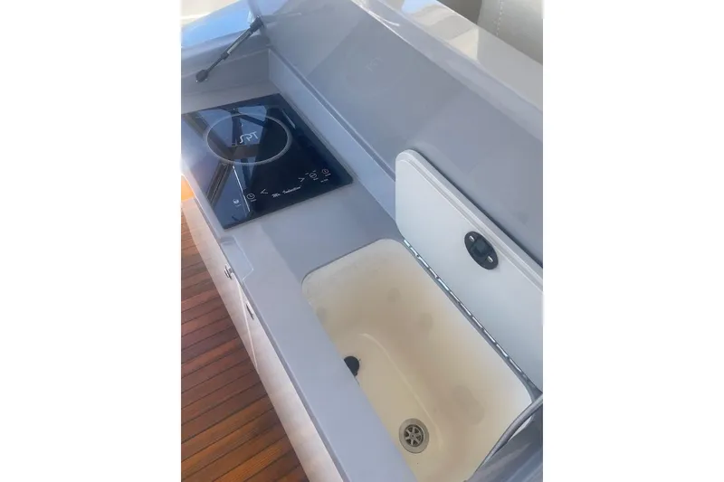 Slide: The Image of 2015 Faeton Formentera boat kitchen with stove and sink, featuring sleek design and wooden flooring. - 19