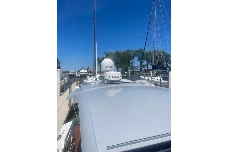 Slide: The Image of 2015 Faeton Formentera boat docked, featuring Garmin and Intellian equipment under clear blue sky. - 24