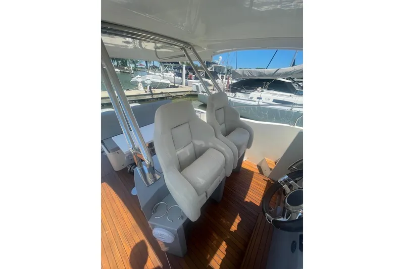 Slide: The Image of 2015 Faeton Formentera boat interior with plush seating and wooden flooring at a marina. - 8