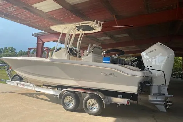 Slide: The Image of 2026 Boston Whaler 250 Dauntless boat on trailer under a metal roof. - 2