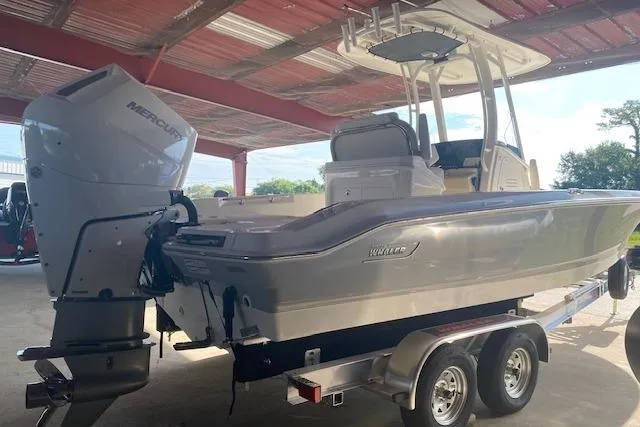 Slide: The Image of 2026 Boston Whaler 250 Dauntless boat on trailer under a metal roof. - 3
