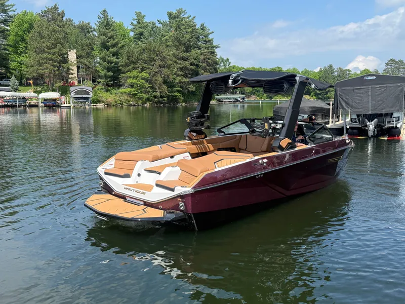 Slide: The Image of A modern motorboat with brown seats is on a calm lake, surrounded by trees. - 2