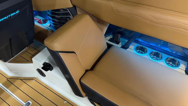 Slide: The Image of Interior of a Nautique Super Air Nautique G23 with brown seats and blue lighting. - 27
