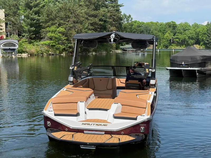 Slide: The Image of A modern motorboat with brown seats is on a calm lake, surrounded by trees. - 3