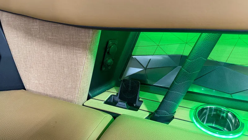 Slide: The Image of Interior of a Nautique Super Air Nautique G23 with green lighting and cup holder. - 32