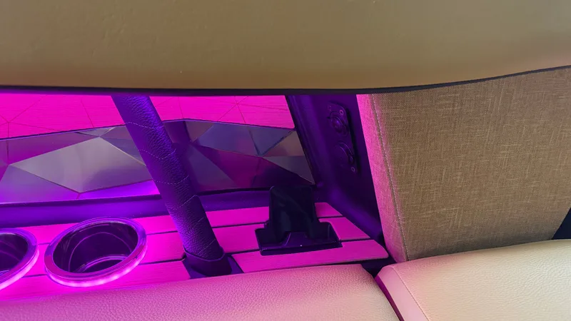 Slide: The Image of Interior of a Nautique Super Air Nautique G23 with purple lighting and cup holders. - 40