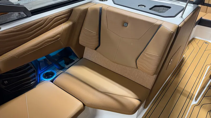 Slide: The Image of Interior of the Nautique Super Air Nautique G23 with brown leather seats and blue lighting. - 48