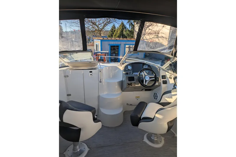 Slide: The Image of Interior of a 2019 Stingray 250 CR boat with steering wheel and seating. - 14