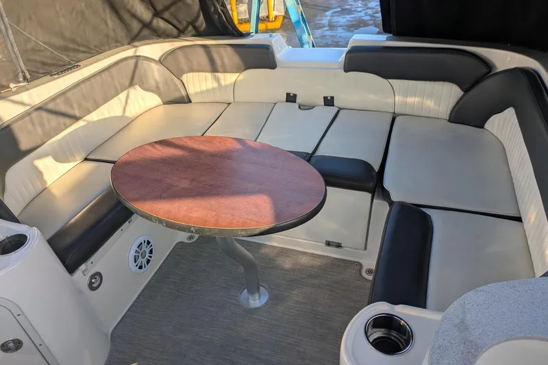 Slide: The Image of 2019 Stingray 250 CR boat interior with cushioned seating and round table. - 15