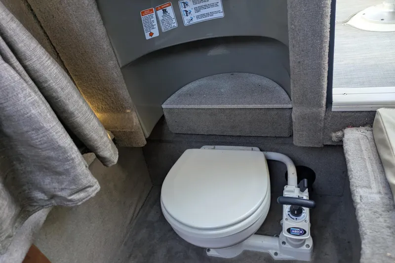 Slide: The Image of 2019 Stingray 250 CR boat interior with compact marine toilet setup. - 18