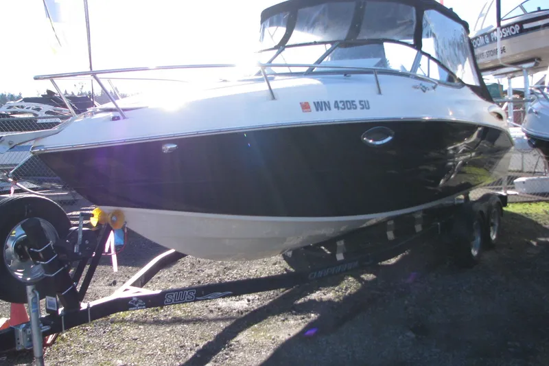 Slide: The Image of 2019 Stingray 250 CR boat on trailer, displayed outdoors in sunlight. - 2