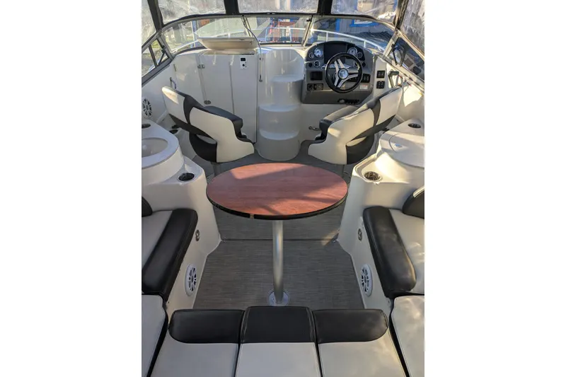 Slide: The Image of 2019 Stingray 250 CR boat interior with seating, table, and steering console. - 7