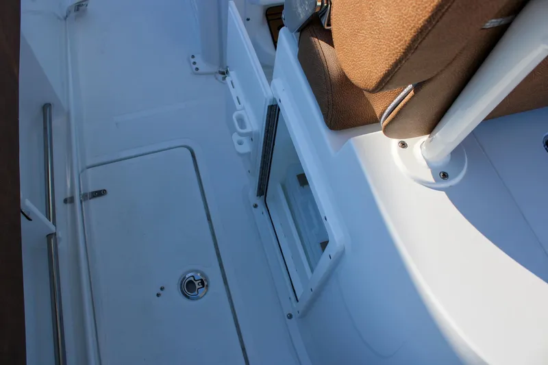 Slide: The Image of 2026 Sea Hunt Gamefish 25 interior with brown seating and storage compartment. - 19