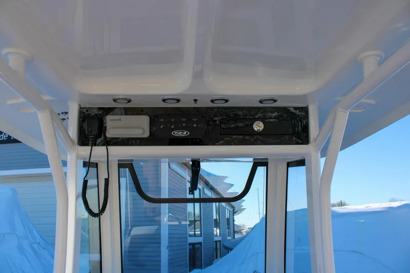 Slide: The Image of 2026 Sea Hunt Gamefish 25 boat console with Garmin equipment and overhead storage. - 25