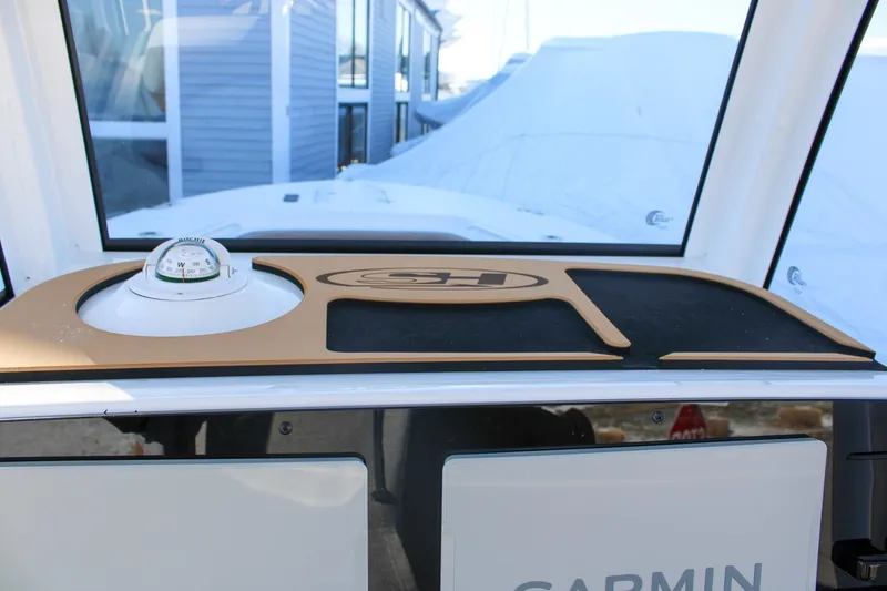 Slide: The Image of 2026 Sea Hunt Gamefish 25 dashboard with compass and Garmin equipment. - 28