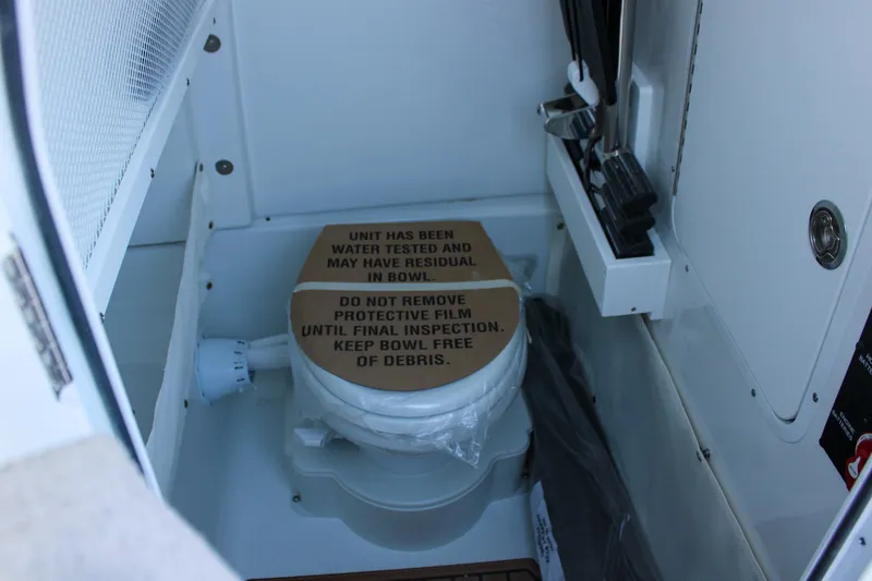 Slide: The Image of 2026 Sea Hunt Gamefish 25 boat toilet with protective cover in compact cabin. - 31