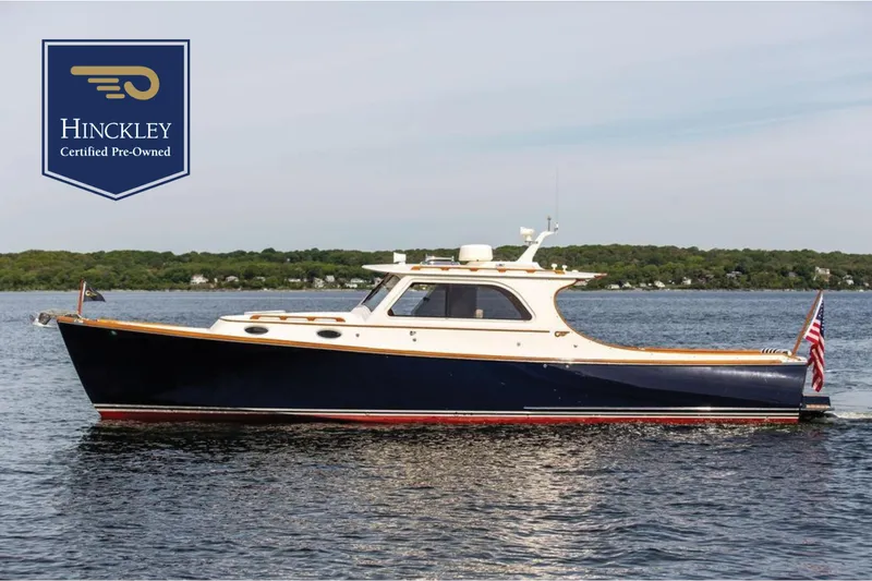 The Image of 2005 Hinckley Picnic Boat EP on water, certified pre-owned, with American flag. - 0