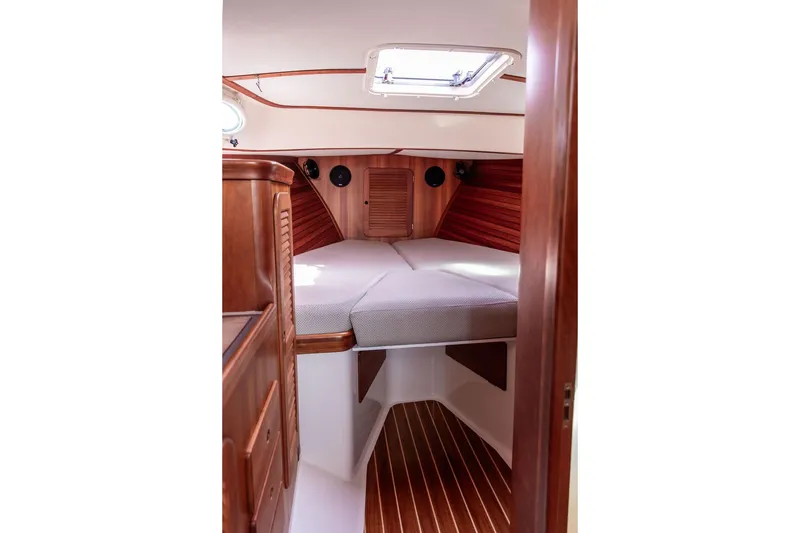 Slide: The Image of 2005 Hinckley Picnic Boat EP cabin interior with wooden finish and cozy bedding. - 11