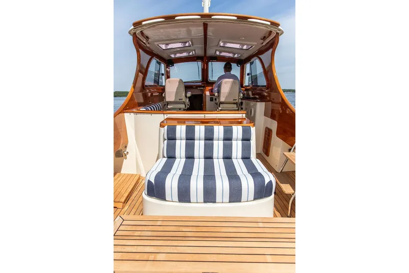 Slide: The Image of 2005 Hinckley Picnic Boat EP with striped seating and wooden deck. - 6