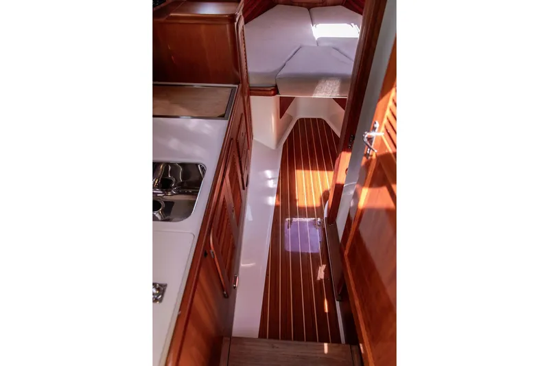 Slide: The Image of Interior of 2005 Hinckley Picnic Boat EP, featuring wood paneling and compact cabin space. - 9