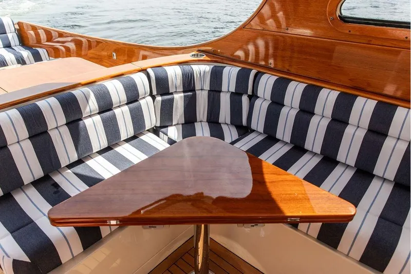 Slide: The Image of Interior of 2005 Hinckley Picnic Boat EP with striped seating and wooden table. - 7