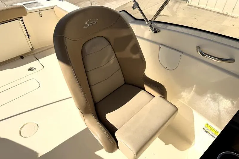 Slide: The Image of 2023 Scout 215 Dorado boat seat, beige leather, sunlight, interior view. - 10