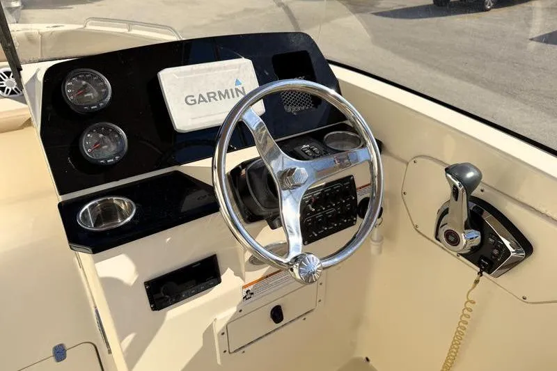 Slide: The Image of 2023 Scout 215 Dorado boat dashboard with Garmin navigation system and steering wheel. - 11