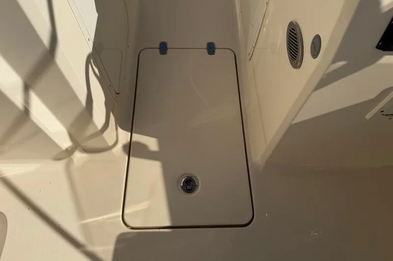 Slide: The Image of 2023 Scout 215 Dorado boat deck with storage compartment and drain plug. - 13