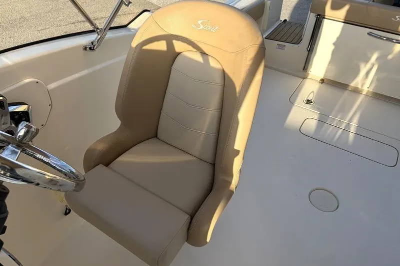 Slide: The Image of 2023 Scout 215 Dorado boat interior with beige captain's chair and steering wheel. - 21