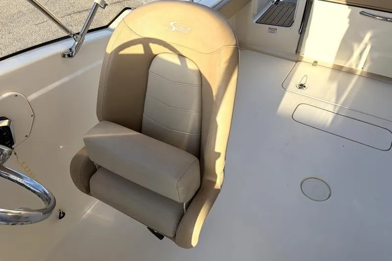 Slide: The Image of 2023 Scout 215 Dorado boat interior with beige captain's chair and steering wheel. - 22