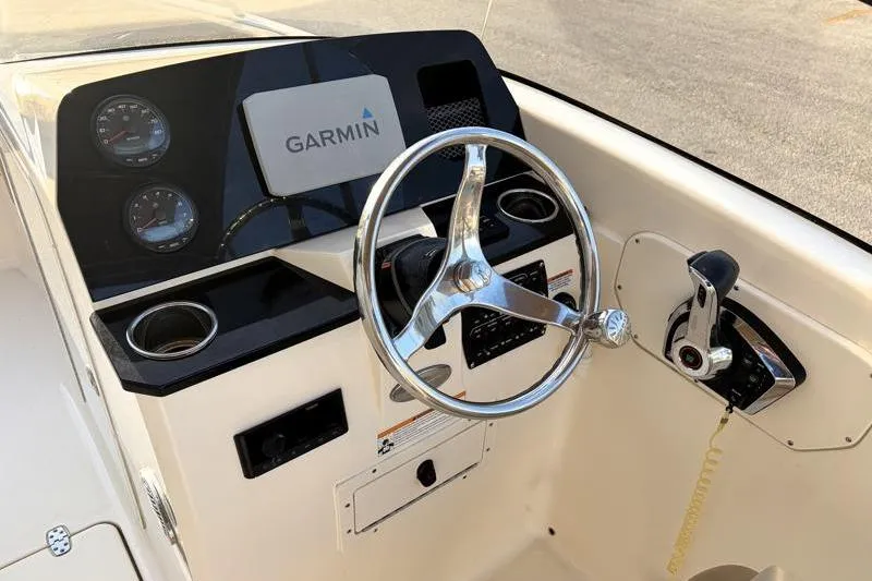 Slide: The Image of 2023 Scout 215 Dorado boat dashboard with Garmin display and steering wheel. - 23