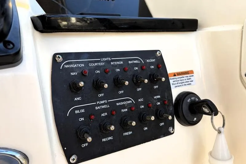 Slide: The Image of Control panel of a 2023 Scout 215 Dorado boat with various switches and key ignition. - 27