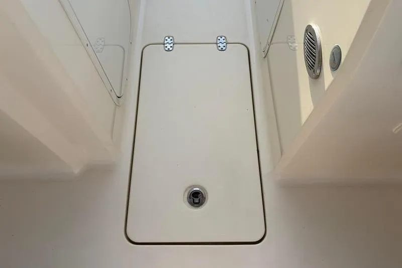Slide: The Image of 2023 Scout 215 Dorado boat storage compartment with secure latch and speaker vent. - 29