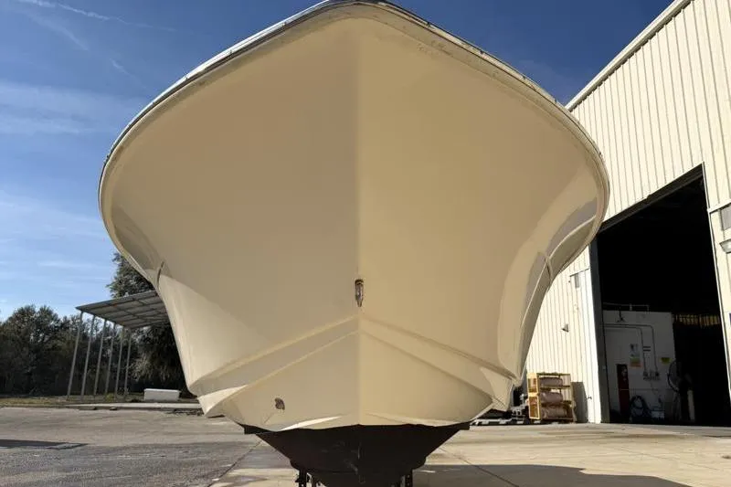 Slide: The Image of 2023 Scout 215 Dorado boat front view near a warehouse. - 4
