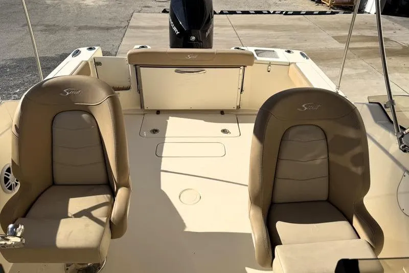 Slide: The Image of 2023 Scout 215 Dorado boat interior with tan seating and outboard motor. - 8