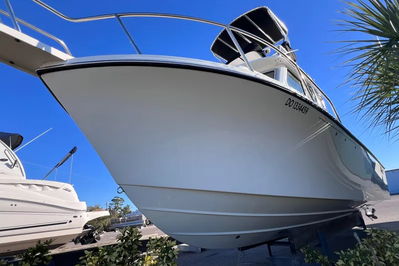 Slide: The Image of 2023 Parker 2820 XLD Sport Cabin boat displayed outdoors under clear blue sky. - 15