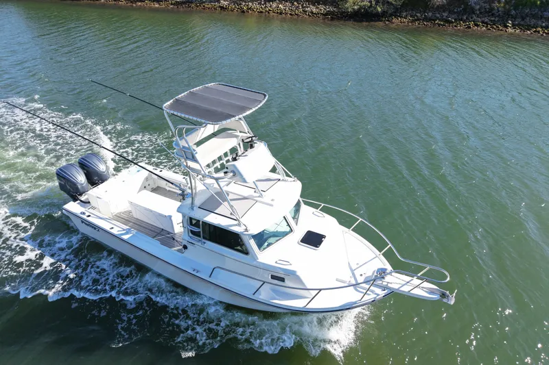 Slide: The Image of 2023 Parker 2820 XLD Sport Cabin boat cruising on a calm waterway. - 2