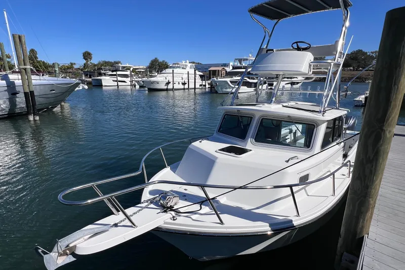 Slide: The Image of 2023 Parker 2820 XLD Sport Cabin boat docked in a marina under clear blue skies. - 26