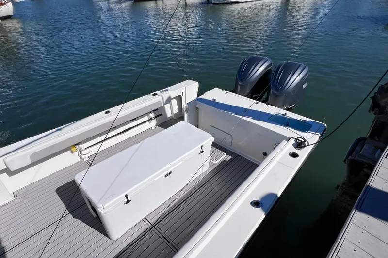 Slide: The Image of 2023 Parker 2820 XLD Sport Cabin boat with dual engines, docked on calm water. - 27