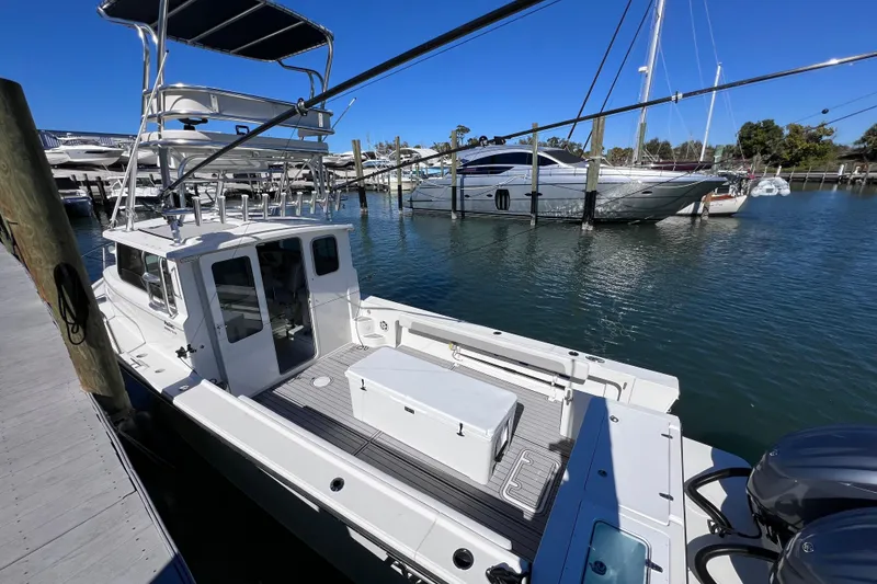 Slide: The Image of 2023 Parker 2820 XLD Sport Cabin boat docked at marina, clear blue sky. - 28
