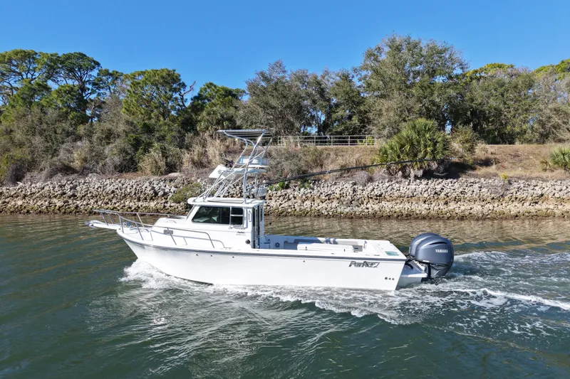 Slide: The Image of 2023 Parker 2820 XLD Sport Cabin boat cruising on a scenic waterway. - 3