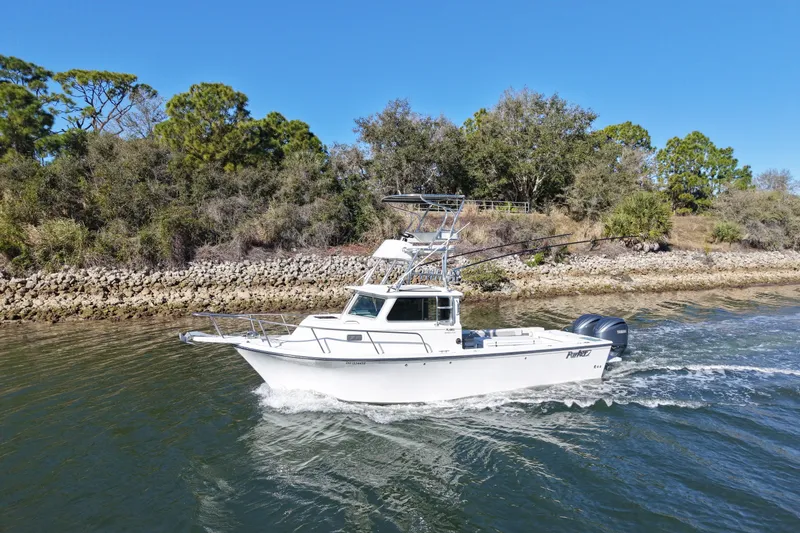 Slide: The Image of 2023 Parker 2820 XLD Sport Cabin boat cruising on a scenic waterway. - 4