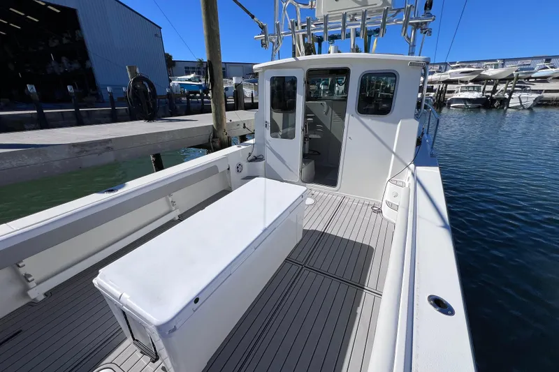 Slide: The Image of 2023 Parker 2820 XLD Sport Cabin boat docked at marina, showcasing spacious deck and cabin. - 40