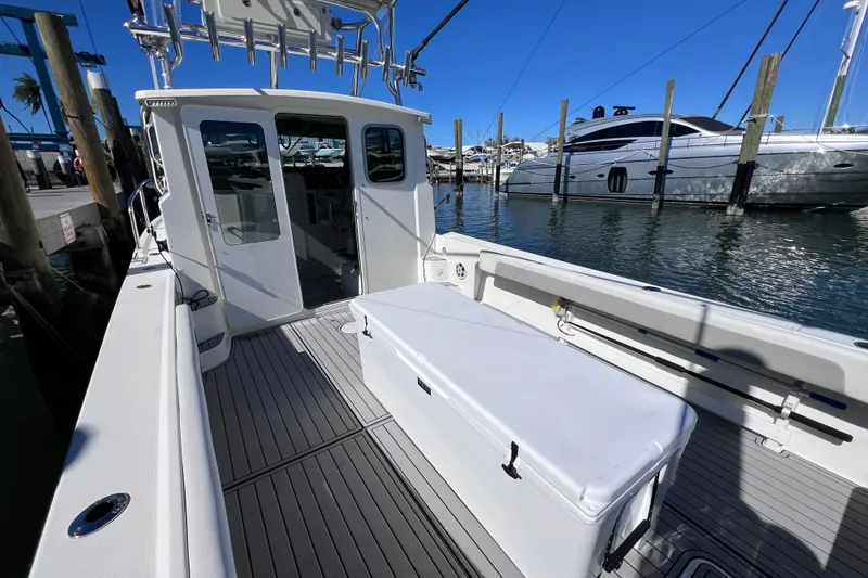 Slide: The Image of 2023 Parker 2820 XLD Sport Cabin boat docked, featuring spacious deck and cabin entry. - 41