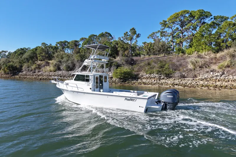 Slide: The Image of 2023 Parker 2820 XLD Sport Cabin boat cruising on a scenic waterway. - 5