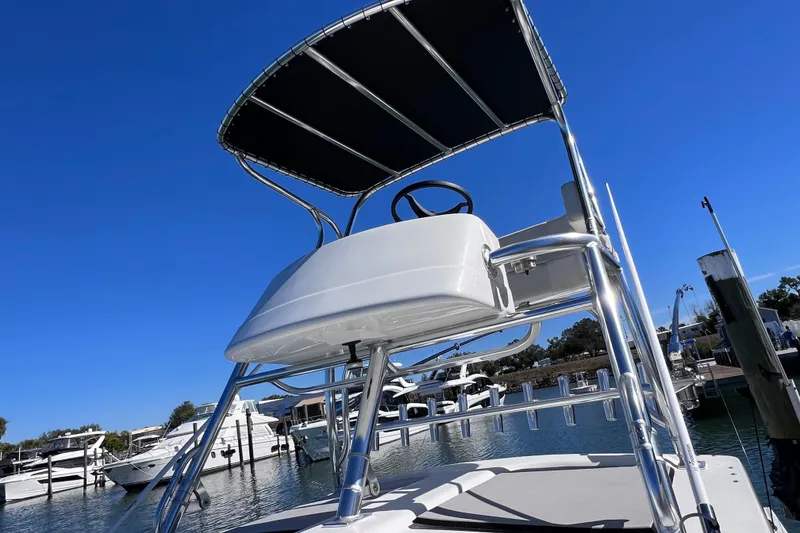 Slide: The Image of 2023 Parker 2820 XLD Sport Cabin boat with elevated helm, docked under clear blue sky. - 52