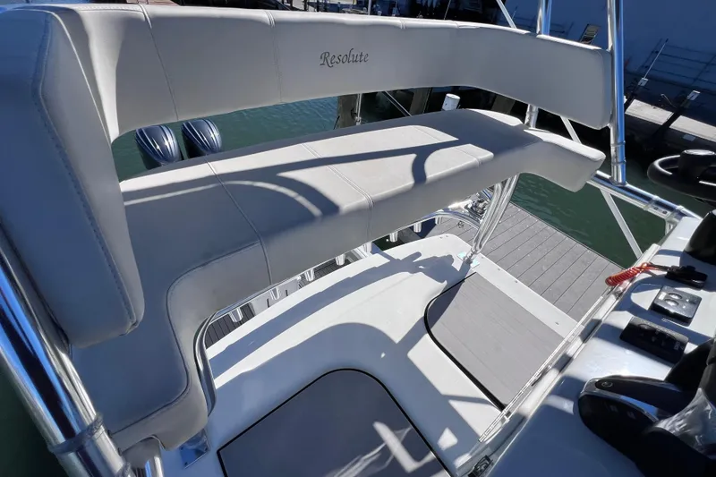 Slide: The Image of 2023 Parker 2820 XLD Sport Cabin boat interior with cushioned seating and dock view. - 53