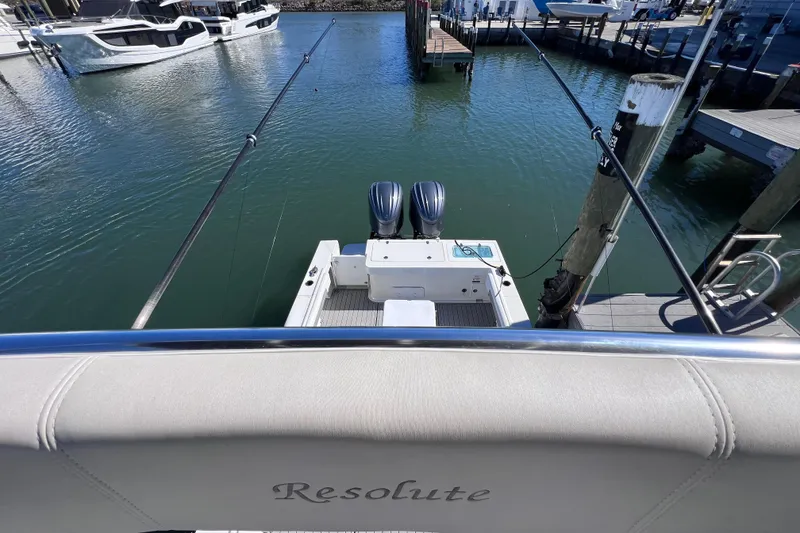 Slide: The Image of 2023 Parker 2820 XLD Sport Cabin boat docked with fishing rods and twin engines. - 54