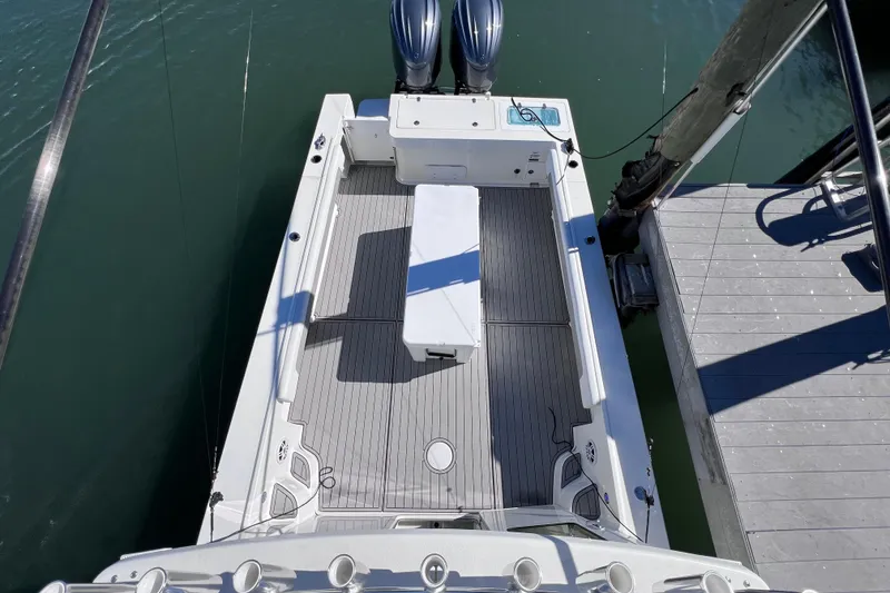 Slide: The Image of 2023 Parker 2820 XLD Sport Cabin boat docked, featuring spacious deck and twin engines. - 55