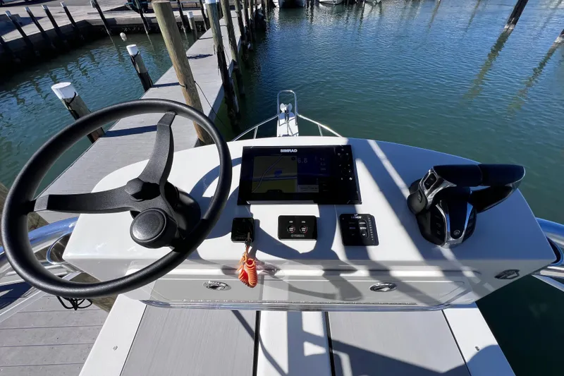Slide: The Image of 2023 Parker 2820 XLD Sport Cabin helm with steering wheel and navigation controls. - 56